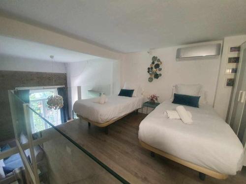 a room with two beds and a table with a window at Indulge in Seville Feria 106 in Seville