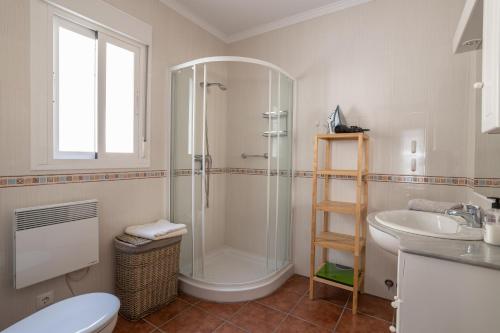 een badkamer met een douche, een toilet en een wastafel bij Casa Flamenca in Canillas de Albaida