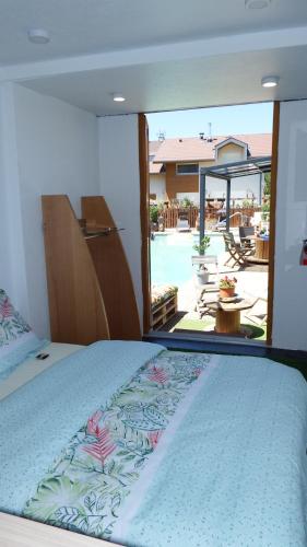 a bedroom with a bed and a view of a pool at Villa Perran Résidence in Thonon-les-Bains