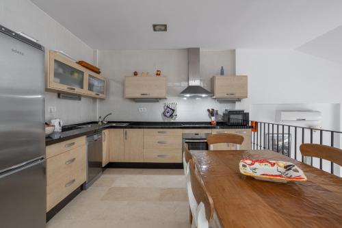 a kitchen with a wooden table and a kitchen with a counter at Casa Curumbico in Almuñécar