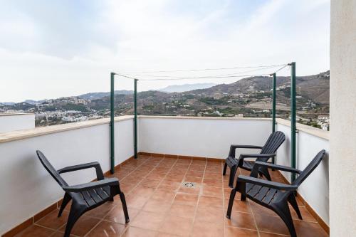 three chairs on a balcony with a view at Casa Curumbico in Almuñécar