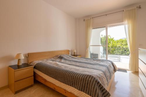 a bedroom with a bed and a large window at Casa Curumbico in Almuñécar