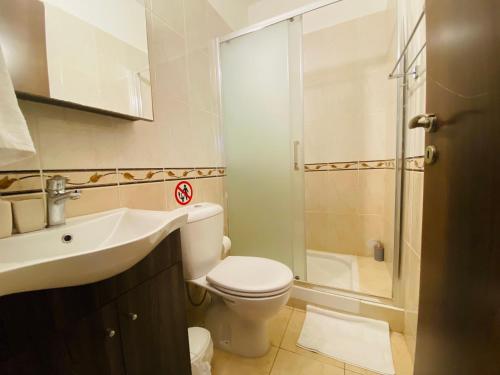 a bathroom with a toilet and a sink and a shower at Apollo 2-BR Apt in Larnaca in Larnaca