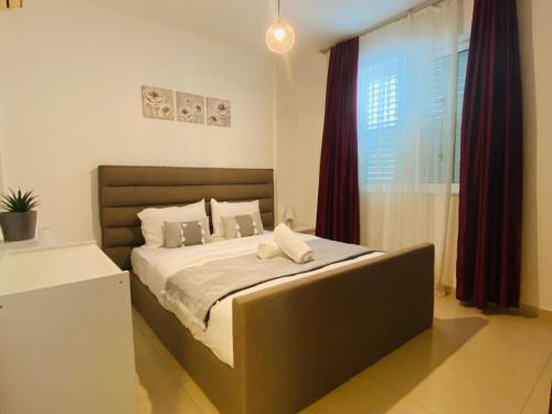 a bedroom with a large bed in front of a window at Apollo 2-BR Apt in Larnaca in Larnaca