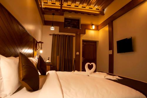 a bedroom with a bed with a heart shaped towel at Stephen's Legacy in Vattavada
