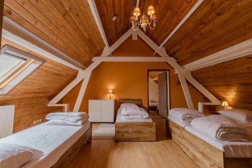 2 Betten in einem Zimmer mit Holzdecke in der Unterkunft De Groene Hoeve in Brakel