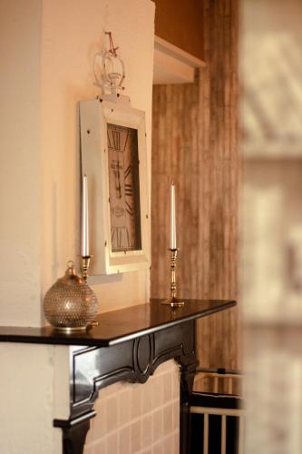 a table with two candles on top of a fireplace at De Groene Hoeve in Brakel