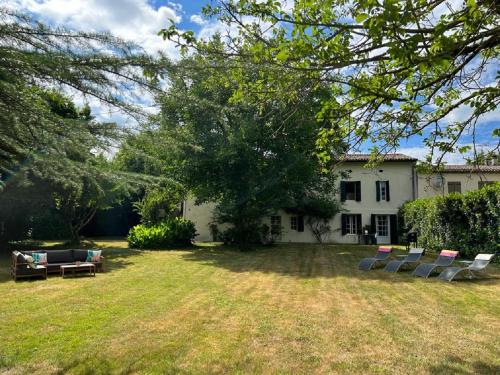 un cortile con sedie e una casa di 2 Bed apartment on the Dordogne River a Saint-Seurin-de-Prats