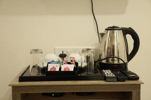 a table with a tea pot and a blender on it at Hotel Centauri in Thiruvalla