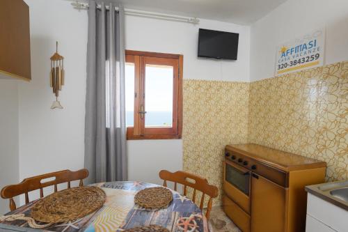 a kitchen with a table and chairs and a window at Salento incantevole alloggio fronte mare in Marittima