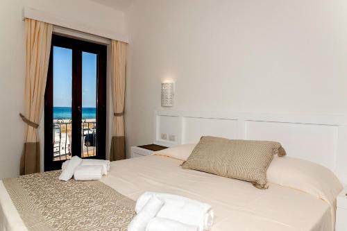 a bedroom with a bed with a view of the ocean at Stella Marina Budoni in Budoni