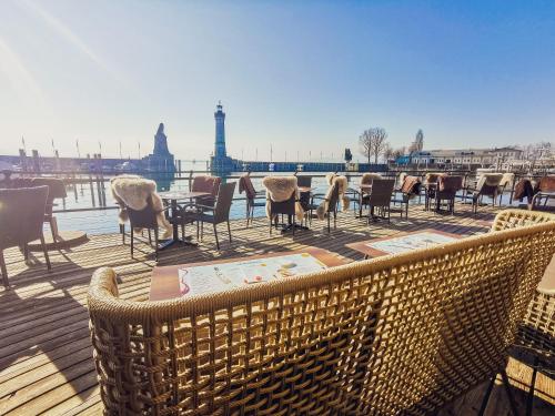 a deck with chairs and tables and a view of the eiffel tower at YachtHotel Helvetia Spa- und Wellnessdomizil in Lindau