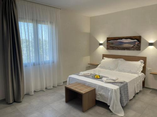 a bedroom with a large bed and a table at Calafato Guest House in Favignana