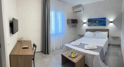 una camera con letto, tavolo e scrivania di Calafato Guest House a Favignana