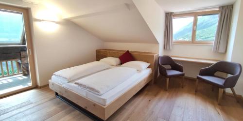 una camera con un letto e due sedie di Mittelbergerhof Ferienwohnungen a Vilpiano