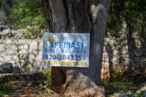 a sign on the side of a tree at Salento incantevole alloggio fronte mare in Marittima