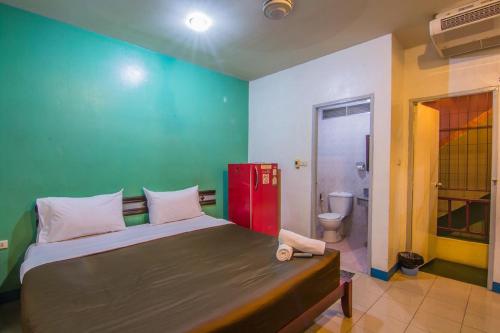 Un dormitorio con una cama grande y una pared verde en Sutus Court 5, en Pattaya central