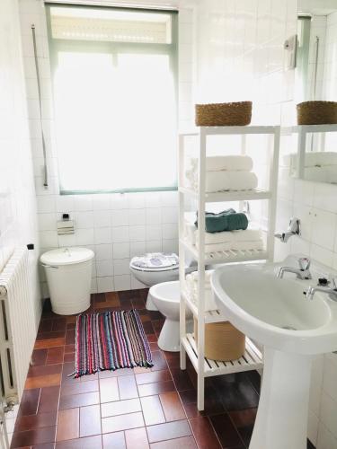 a white bathroom with a sink and a toilet at Casa CHORIMA in Arzúa