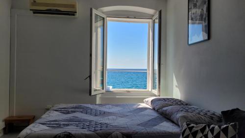 um quarto com uma janela com vista para o oceano em Apartment LOTI em Piran