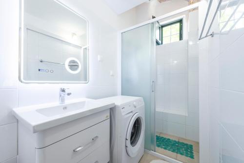 a white bathroom with a sink and a washing machine at Unique Cavtat Center Apartment in Cavtat