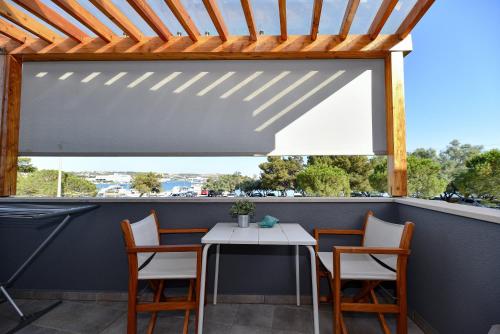 patio con mesa, sillas y ventana en Apartments Villa Clementa, en Zadar