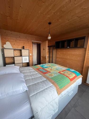 un grand lit dans une chambre avec un plafond en bois dans l'établissement Galerie Roche Beranger « Le doux Chalet », à Chamrousse