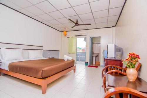 a bedroom with a bed and a desk and a tv at Sutus Court 3 in Pattaya Central