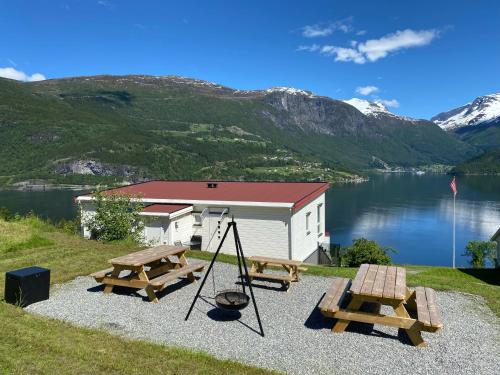 a picnic area with two picnic tables and a building at Olden Fjord Apartments in Olden
