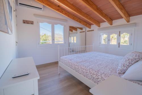 アルクーディアにあるVilla PARAISO Alcudiaの白いベッドルーム(ベッド1台、窓2つ付)