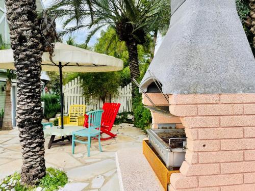 a patio with colorful chairs and an outdoor grill at Out of Africa Resort in Had Nes