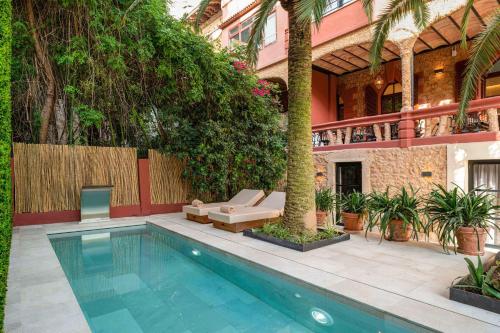 a swimming pool in the middle of a courtyard with a house at Hotel Can Quetglas in Palma de Mallorca