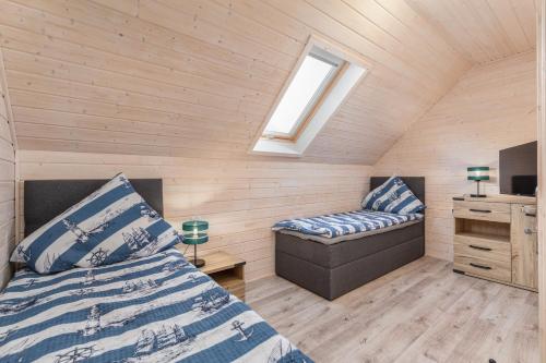 a bedroom with a bed and a chair in a room at Ośrodek Wypoczynkowy DAKAR in Rewal