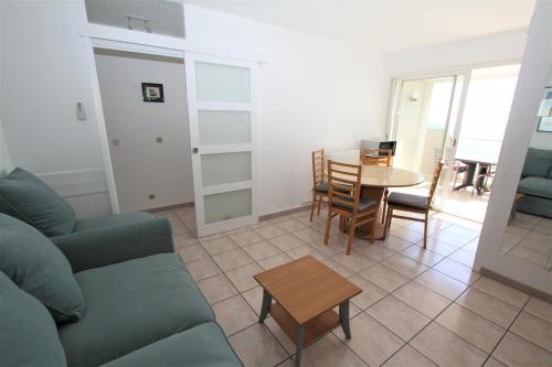 un salon avec un canapé et une table dans l'établissement Appartement 2 pieces en front de mer, à Canet