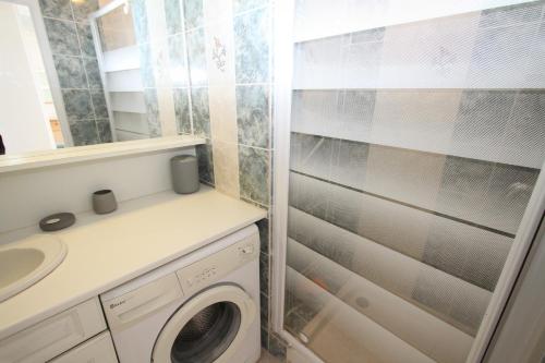 une salle de bain avec une machine à laver et un lavabo dans l'établissement Appartement 2 pieces en front de mer, à Canet