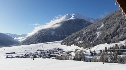 une station de ski dans les montagnes avec de la neige au sol dans l'établissement Haus Ursula, à Kals am Großglockner