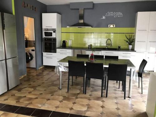 eine Küche mit einem Tisch und Stühlen in der Unterkunft Maison avec Piscine in Agde