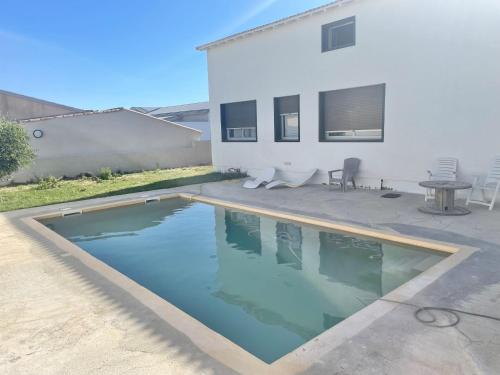 a swimming pool in front of a house at Maison avec Piscine in Agde