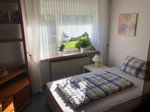 een slaapkamer met een bed en een raam met planten bij Haus Porta in Porta Westfalica