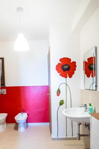 a bathroom with a red wall and a toilet and a sink at Orvieto Rocca Fiorita in Orvieto