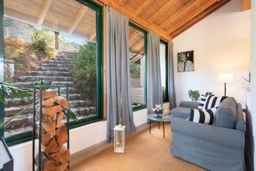 a living room with a couch and a large window at AGROLOGY LUX - 4 BEDROOM Luxurious villa on an Agricultural Haven Retreat in Sálakos