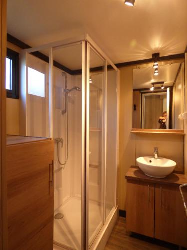 une salle de bain avec douche et lavabo dans l'établissement Camping Le Transat, à Foulerot