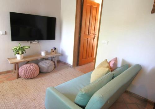 a living room with a blue couch and a flat screen tv at Vila Lobo Algarve in Faro