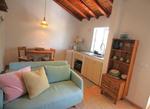 a living room with a blue couch and a kitchen at Vila Lobo Algarve in Faro