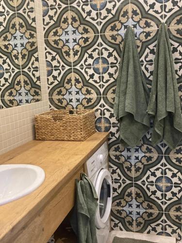 a bathroom with a sink and a washing machine at LUČI jūras apartamenti 2 in Roja