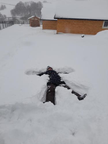 a person is laying in a pile of snow at Spiska Dolina in Łapsze Niżne