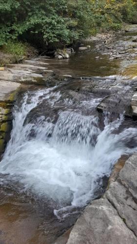 a small waterfall in a river with rocks at Spiska Dolina in Łapsze Niżne