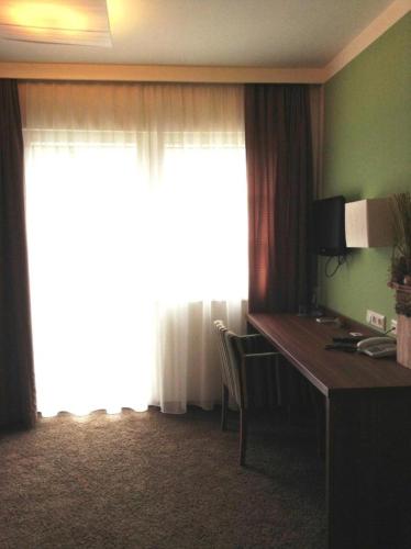 a hotel room with a desk and a window at Gasthof & Hotel Wolfsegger in Engerwitzdorf