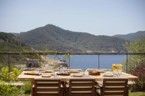 una mesa de madera con sillas y vistas al agua en Six Senses Ibiza, en Portinatx