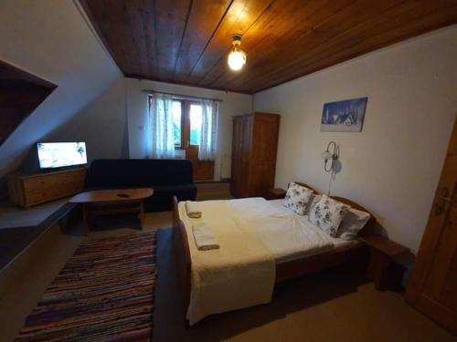 a bedroom with a large bed and a living room at Mała Bawaria in Zakopane