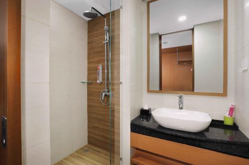 a bathroom with a sink and a shower at favehotel Nagoya - Batam in Batam Center